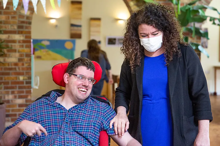 Male resident smiling with care worker