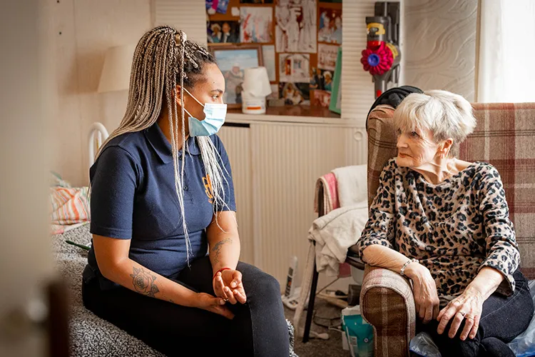 Care worker Care worker sitting talking to resident