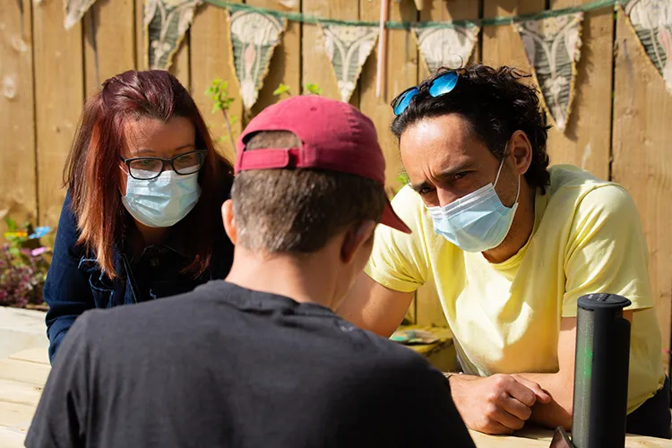 Care workers and man sitting outside